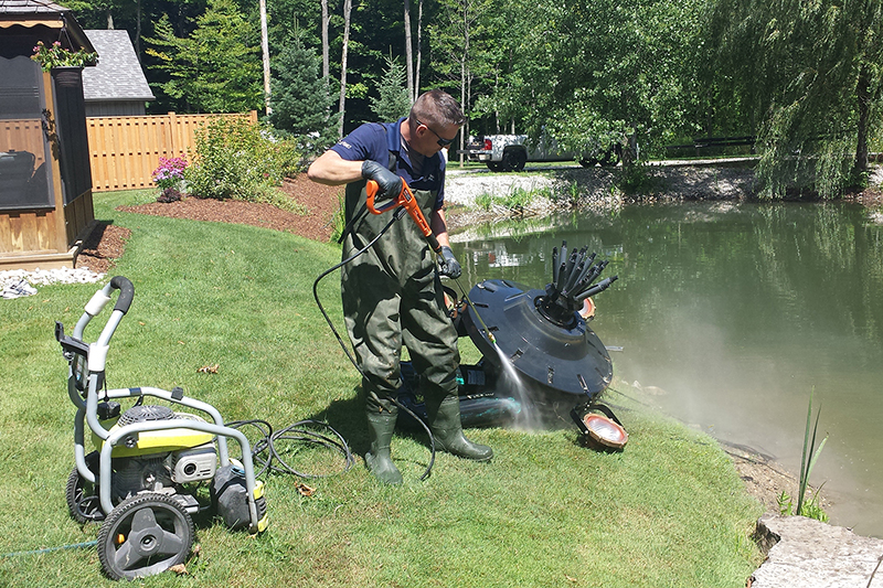 Floating fountain pulled from the pond and power washed during maintenance
