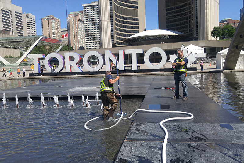 Technicians cleaning the Nathan Phillips Square fountain