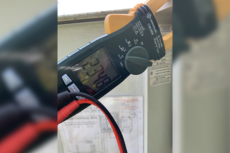 Clamp meter reading the electrical load on a floating fountain power cable