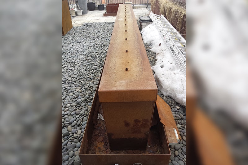 Corten steel water trough before repair in a Toronto landscape