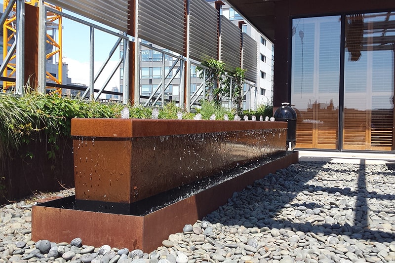 Restored corten steel water feature running again after cleaning and repair in Toronto