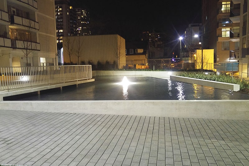 Lit plaza fountain at night in Toronto