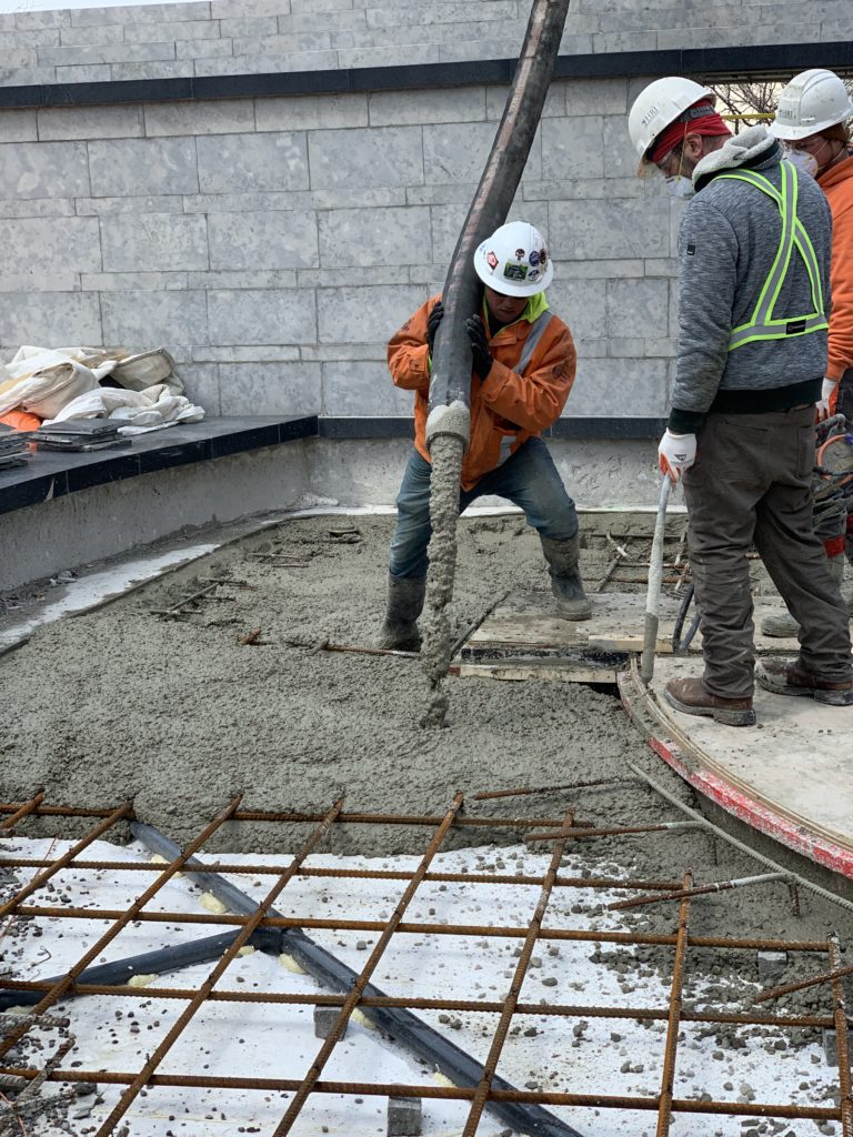 Concrete poured over structural foam, rebar and piping to encapsulate everything in one structure